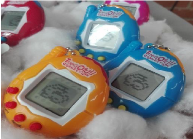 Tres dispositivo Tamagotchi azules y amarillos