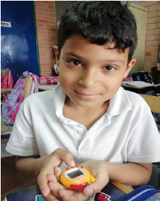 Un estudiante mirando a camara con un tamagotchi en la mano